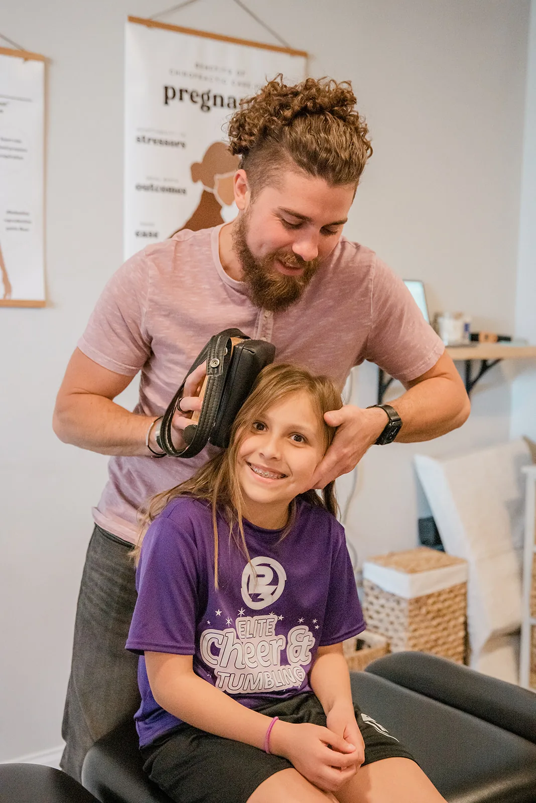 Smiling child receiving gentle chiropractic adjustment