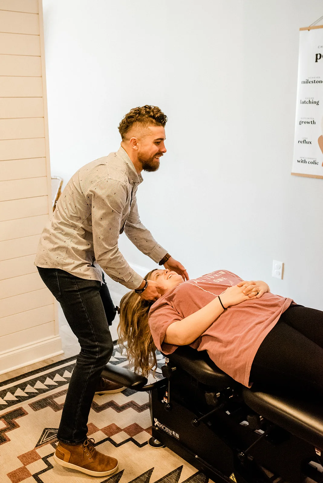 Doctor performing neck adjustment on smiling patient
